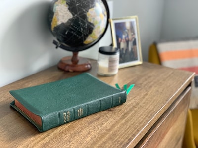 棕色木桌上的绿色精装书